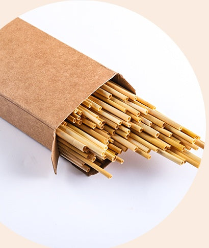 Natural Wheat Reusable Straw pack with multiple straws peeking out of a brown cardboard box.