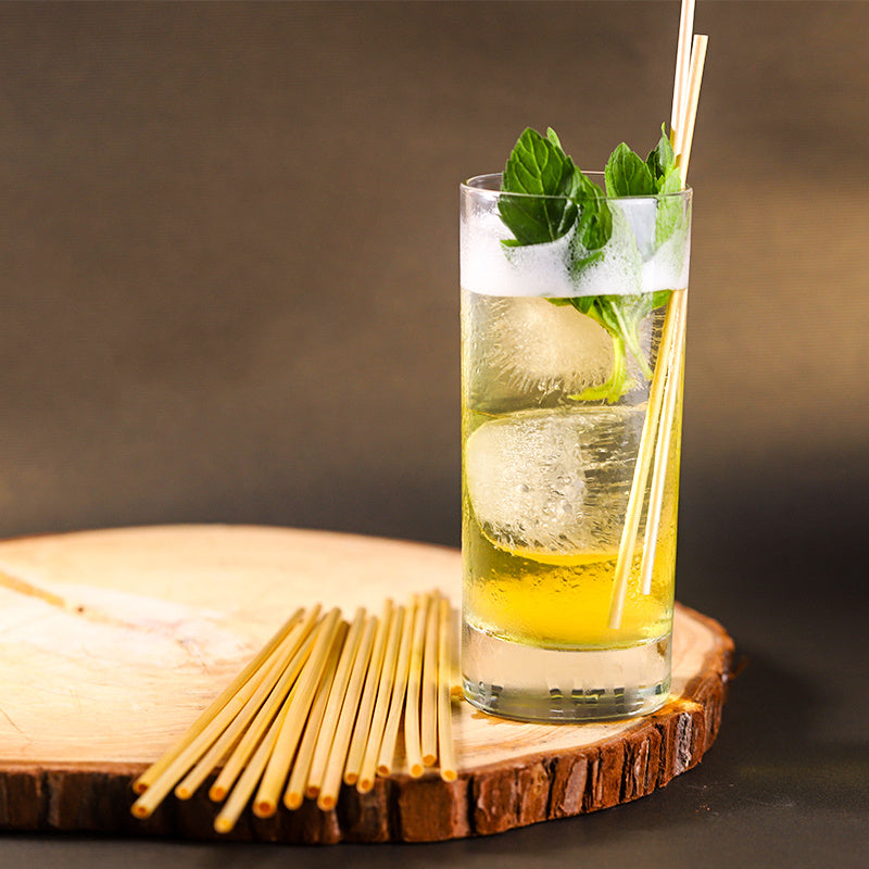 Natural Wheat Reusable Straw in a refreshing drink on a wooden table, promoting sustainable sipping.